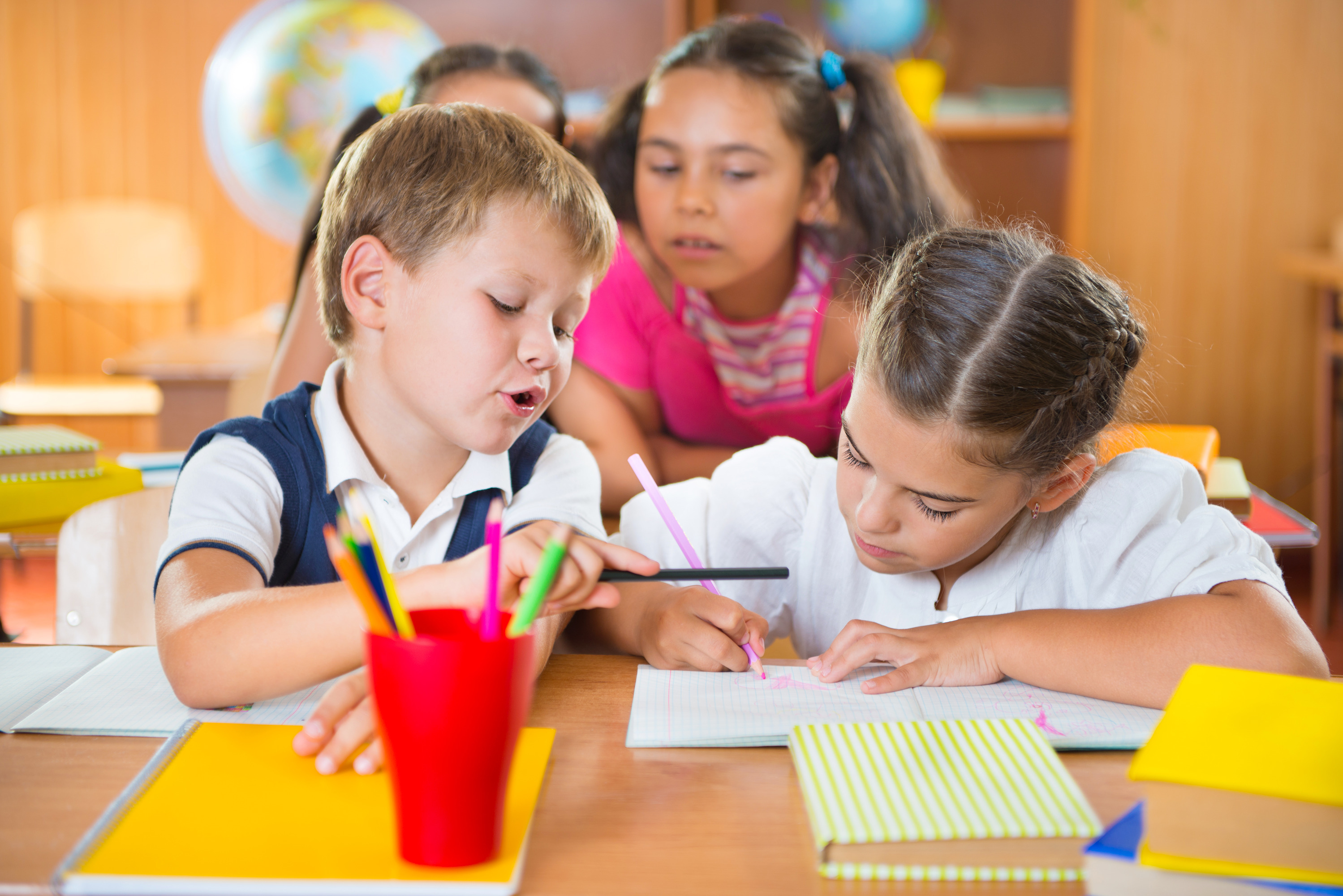 Happy elementary students in classroom at school